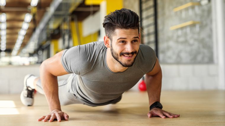 O persoana intr-o camasa gri care face flotari.