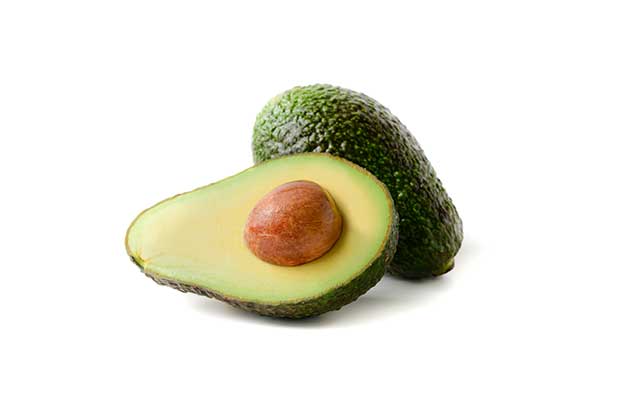 Jumatate de avocado cu un avocado intreg in spate.